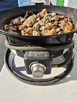 Front view showing lava rocks, control knob with Outland branding, attached hose