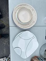 Stack showing both round and square porcelain plates and bowl