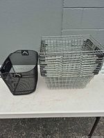 black bicycle basket and stacked silver wire baskets on table