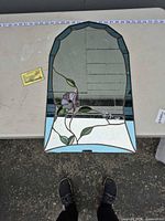 Front view of arched stained glass mirror on table showing full design