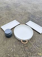 Group shot of round tray, two platters and canister