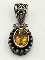 Front view of sterling silver pendant showing citrine, bead halo and bale detail