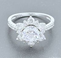 Angled view showing floral halo design, central stone, pavé shoulders, 925 stamp visible inside band