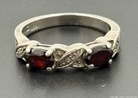 Front view showing three red stones, silver band and decorative accents