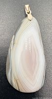 Front view of teardrop banded agate pendant with silver bail