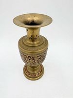 Front view of brass candle holder showing full form and decorative band