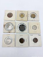 Front view of nine coins arranged 3×3 in cardboard holders