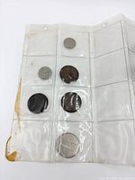 Left section of coin sleeve showing five coins including large Manitoba token