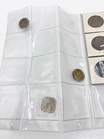 Overall view of vinyl album page with three loose coins