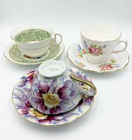 Three teacup and saucer sets displayed