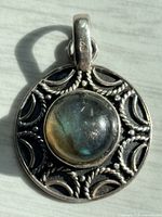 Front view of pendant showing labradorite stone and decorative silver border