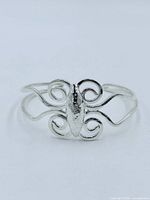 Front view of sterling silver cuff showing scroll centerpiece and split shank