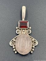 Front view of sterling silver pendant with rose quartz and red stone