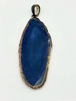 Front view of blue stone pendant with gold-tone edge