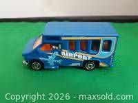 Left side view of blue Matchbox airport bus with graphics