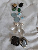 All five earring pairs laid out on fabric surface