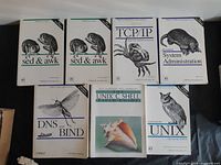 Seven computer books laid out front covers visible