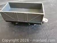 Gray open cargo wagon side view showing paneled sides and interior