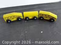 Front angled view of all three yellow magnetic wooden train cars connected