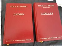 Front covers of both red hardcover books showing titles and publisher