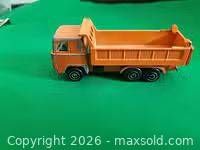Side view of orange diecast dump truck
