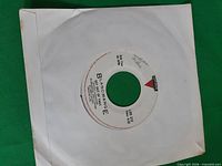 Record in white sleeve showing centre label