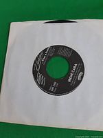 Record partially inside plain white sleeve showing label