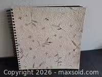 Front view of spiral-bound album showing textured cover with pressed foliage