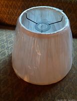 Side view showing pleated fabric, protective plastic, overall shape