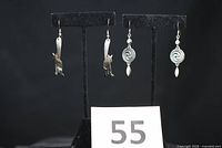 Both pairs of earrings on display stands with lot number