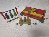 Overview showing all three wooden Holgate toys with blocks, pegs and milk bottles