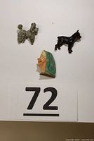 Grey poodle, black terrier, and lady’s face brooches on white background