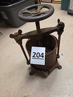 Full view of cast iron screw press with handwheel and basket