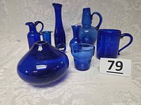 All seven cobalt blue glass items grouped
