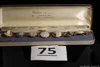 Full bracelet in open presentation box showing seven cameos and clasp