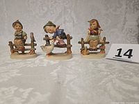 Front view of all three Goebel Hummel figurines with size reference card