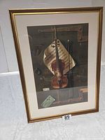Framed matted print depicting violin still life