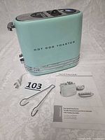 Toaster, tongs, power cord, instruction manual visible