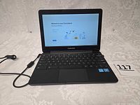 Chromebook open and powered on with charger attached