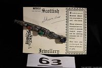 Full view of brooch on original card showing stones and length reference