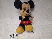 Front view of Mickey Mouse plush seated with tag visible