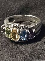 Front view showing five coloured gemstones and sterling band