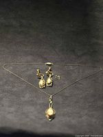 Necklace, earrings and loose beads laid flat on black background