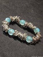 Bracelet overview showing metal ring clusters and blue beads