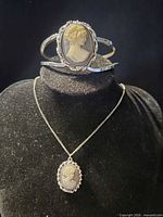 Bangle bracelet and necklace displayed on bust to show cameo details