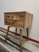 Front angled view showing two drawers, knobs, legs