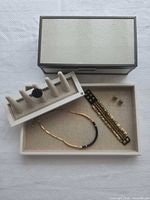 Overview of jewelry items in tray, ring on display stand and ivory jewelry box