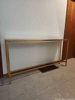 Front view of glass top console table against wall