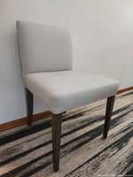 Front angled view of grey faux leather chair