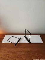 Shelf board with two metal brackets displayed on tabletop